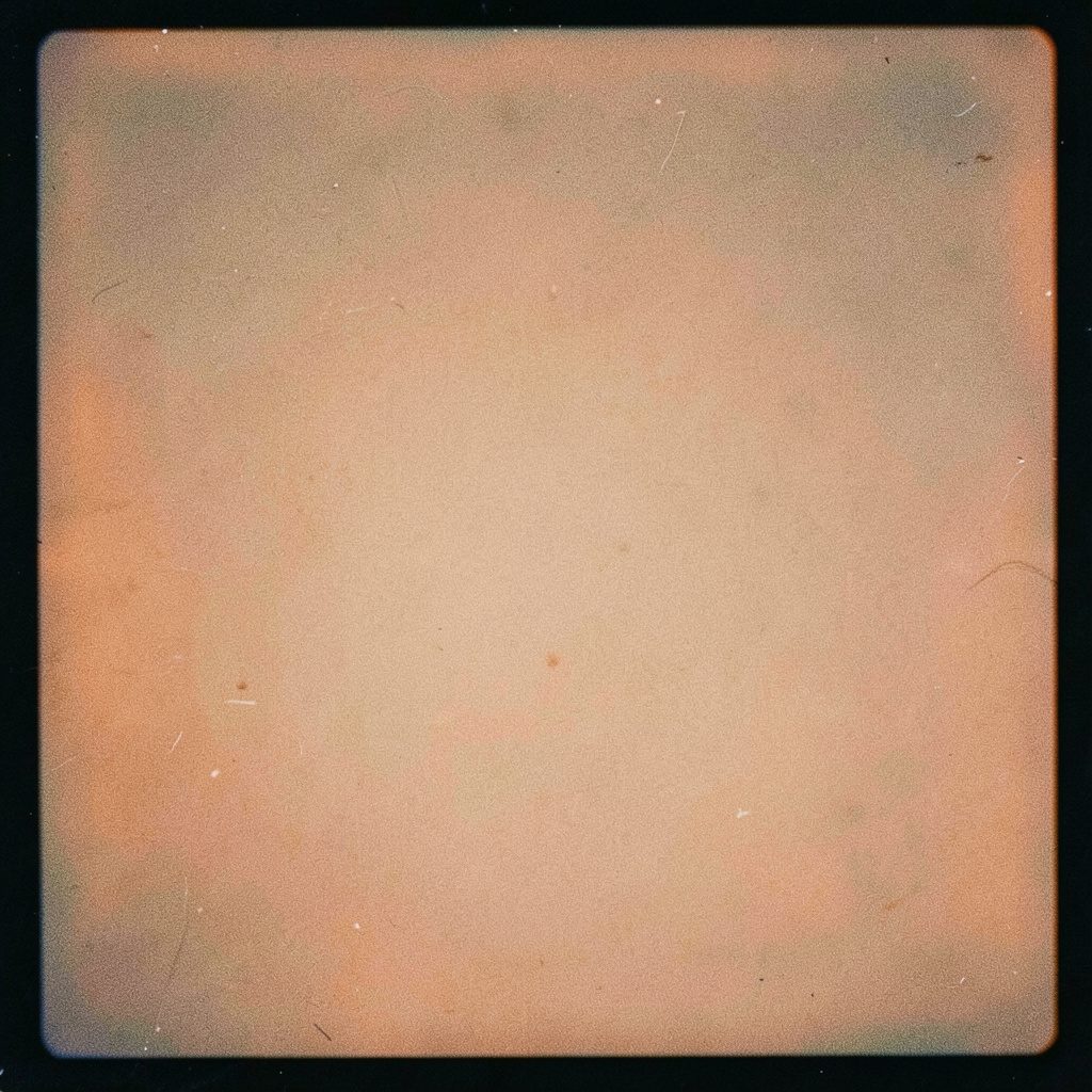 Striscia fotografica con toni caldi ambra e sfumature di nero, atmosfera vintage da pellicola analogica con grana visibile, evocando bacheche di annunci e trascrizioni di giornali di seconda mano